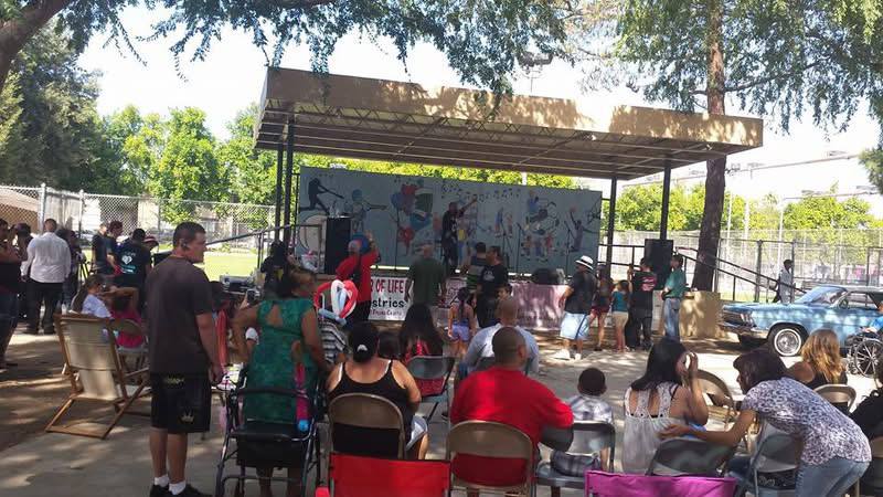Crowd gathered at an outdoor outreach stage