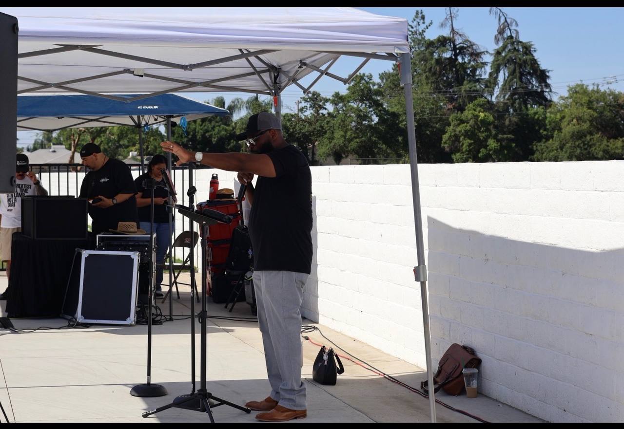 Pastor Elliott Murray preaching at an outdoor outreach